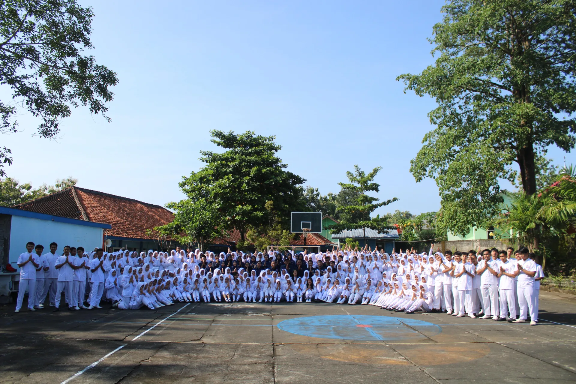 Seluruh siswa berseragam putih berfoto bersama di halaman sekolah
